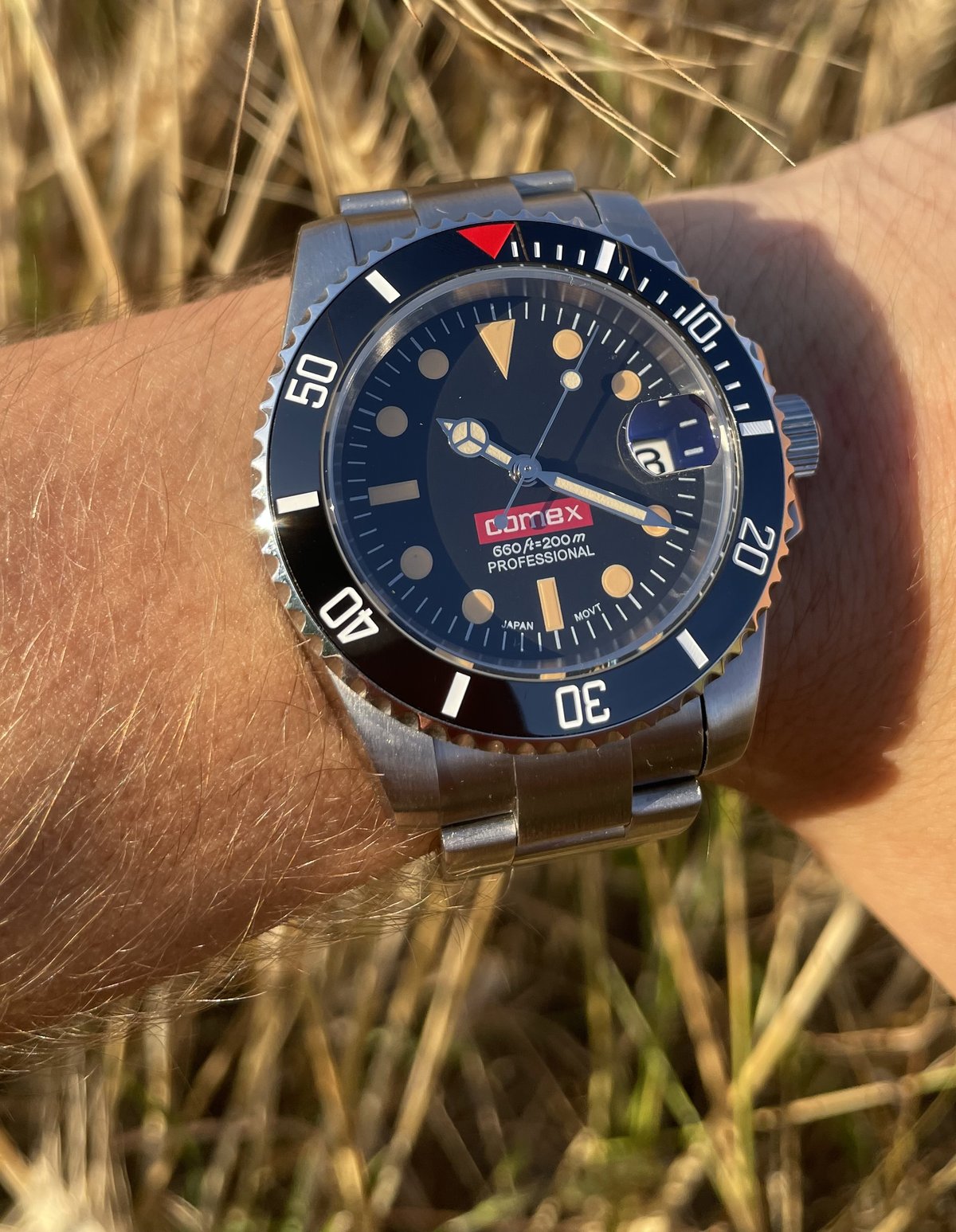 SUB MOD COMEX au poignet dans un champ de blé